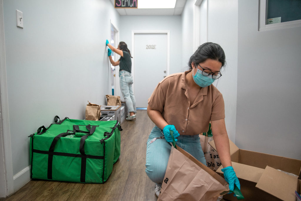 A mutual aid volunteer a Southeast Asian Community Alliance prepares care packages for a delivery.